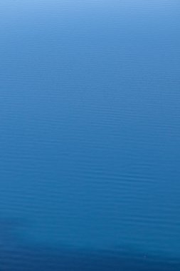 Küçük dalgaların rahatlatıcı arka planı ve canlı mavi suyun dalgaları