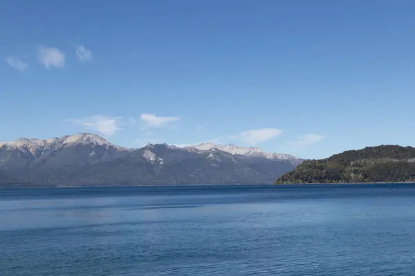 Yoğun ormanlarla dolu sakin ve rahatlatıcı dağ sırasının yatay görüntüsü gölün durgun su duvar kağıdına yansıyor.
