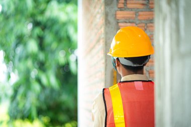 İnşaat işçisi yapının her parçasının uyduğundan emin olmak için inşaat standartlarını denetliyor..