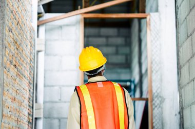 İnşaat işçisi yapının her parçasının uyduğundan emin olmak için inşaat standartlarını denetliyor..