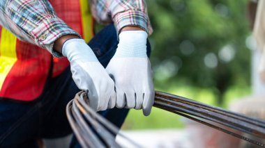 İnşaat alanındaki güçlendirilmiş çelik parmaklıkları işleten işçiler.