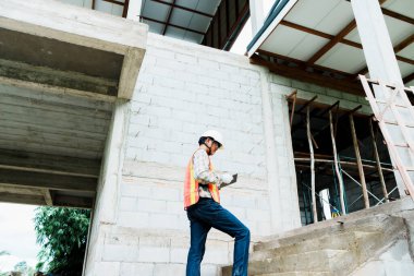 İnşaat işçisi inşaat alanını inceliyor..