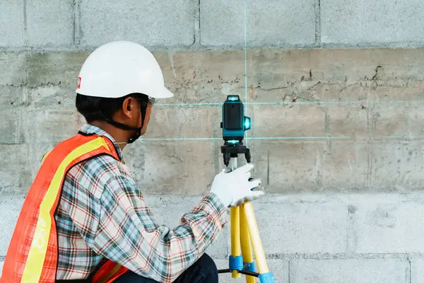 Ölçüm için Lazer Seviye Aracı kullanan İnşaat İşçisi