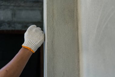 İnşaat işçisi inşaat alanında duvarları sıva ile kaplıyor. Ev dekorasyonu kavramını yakından inceliyor.