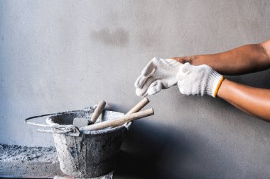 İnşaat işçisi inşaat alanı faaliyeti hazırlıyor. Kapalı alanda çekilmiş çevre görüntüleme işçiliği odaklı.