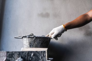 İnşaat işçisi çimento karıştırma atölyesi endüstrisi uyguluyor kapalı alanda yakın plan işçiliği ve hassasiyet