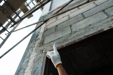 Şehir sitesinde inşaat çalışması devam etmekte olan el yapımı tuğla kurulumu dış görünüş işçiliği odaklı