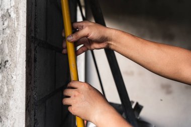 Şehir merkezindeki duvarı ölçen inşaat işçisi endüstriyel çevreye odaklı bakış açısı