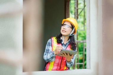 İnşaat işçisi planlarını değerlendiriyor. İnşaat sahası profesyonel göz düzeyi proje yönetimi görüşleri.