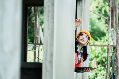 İnşaat işçisi, açık hava çalışmalarını gözlemliyor. Fotoğrafçılık doğası, görüş açısını yükseltiyor.