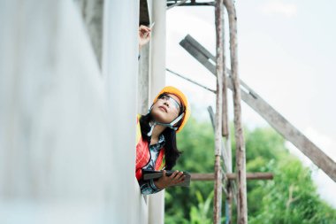 İnşaat işçisi bina yapısını teftiş ediyor. Dış mekan fotoğrafçılığı kentsel çevre. Yakın çekim güvenlik odağı.