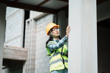 İnşaat işçisi inşaat alanındaki yapısal sütunları teftiş ederken odaklanmış perspektif görüntüsü alındı
