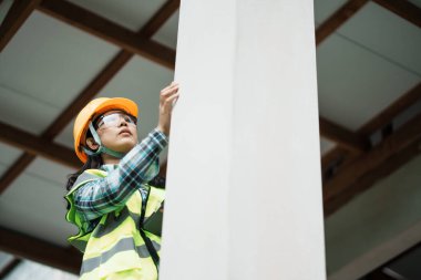 Proje alanındaki çelik kirişi denetleyen inşaat işçisi güvenlik farkındalığı için endüstriyel çevre perspektifini yükseltiyor