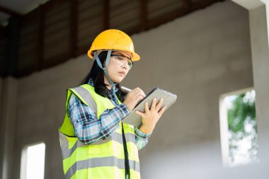 Proje yönetimi inşaat alanı portresi için tablet kullanan inşaat işçisi