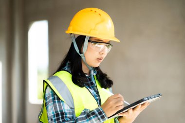 Tablet inşaat alanı endüstriyel aktivitesini kullanan inşaat işçisi kapalı alan çevresi yakın çekim modern teknoloji entegrasyonu