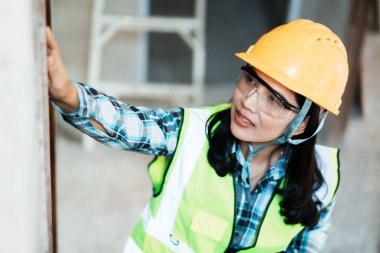 İnşaat işçisi proje sitesi kentsel alan portresini inceliyor kapalı alan çevresi yakın güvenlik taahhüdü