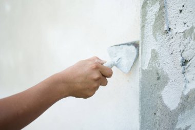 Ev yenileme tesisinin duvarlarına alçı yapıştırılıyor. İnşaat süreci kapalı alanda yakın çekim görüntü teknikleri.