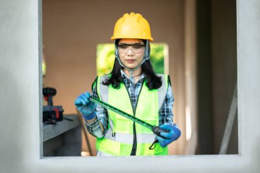 İnşaat işçisi, bir inşaat sahasında yer ölçüyor. Sanayi bölgesi fotoğrafçılığı. Kapalı alanda hassasiyet ve güvenlik.