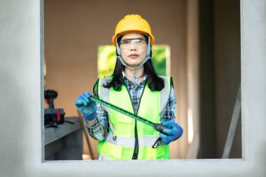 İnşaat işçisi kapalı bir inşaat sahasındaki boyutları ölçüyor profesyonel bağlam odaklı bakış açısı