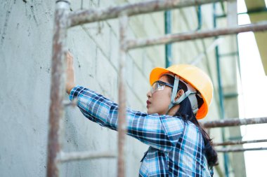 İnşaat işçisi duvar endüstriyel sahasına son rötuşları uygularken kentsel çevre manzaralı profesyonel işçilik