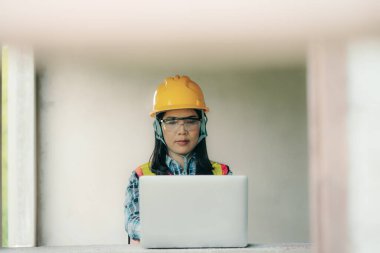 İnşaat işçisi dizüstü bilgisayar sitesi profesyonel portre kullanıyor. Kapalı alan çevresi odaklı modern teknoloji kullanımı