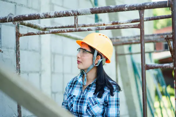 İnşaat işçisi inşaat alanındaki inşaat iskelesini inceliyor kentsel çevre, profesyonel portre güvenlik donanımı