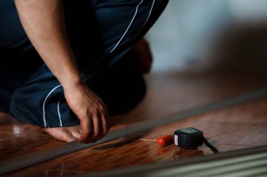 Zemin boyutları ölçülüyor. Ev yenileme dirim projesi. Kapalı alanda hassasiyet ve planlama ayarlanıyor.