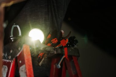 Ev onarımı için bir merdiven üzerindeki araçlar denetleniyor. İç mekanda çekim odaklı ortam odaklı düşük açı görünüm diy kavramı