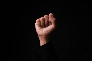 Güçlendirmek için kaldırılan sembolik yumruk karanlık arka plan el hareketi stüdyo ortamının yakın çekim sosyal konular