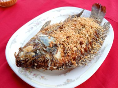Kızarmış tilapia serpiştirilmiş garli.
