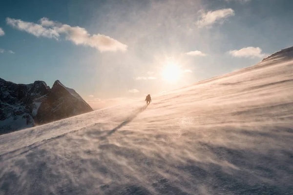 ノルウェー ロフトテン島のライテン山で夜の吹雪の中で雪の山に登る旅行者 — ストック写真