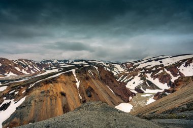 İzlanda 'nın Landmannalaugar şehrinde yaz mevsiminde Blahnjukur yolu karla kaplı görkemli volkanik dağ.