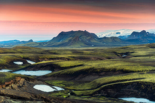 Stunning landscape of volcanic mountain hill with moss covered in remote wilderness on lava field in the sunset at Highlands of Icelan