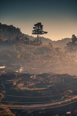 Traditional tribe village with tree on hill in the foggy at the morning. Remote location at Wiang Haeng, Chiang Mai, Thailand