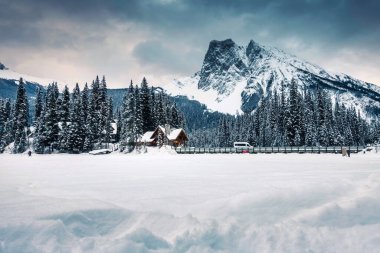 Zümrüt Gölü 'nün güzel manzarası, ahşap kulübe ve kışın karla kaplı kayalık dağlar Yoho Ulusal Parkı, Alberta, Kanada
