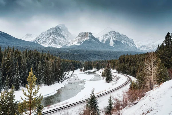 stock image Viewpoint of Morants Curve with railway passing through bow valley and rocky mountains in winter at Banff national park, Alberta, Canada