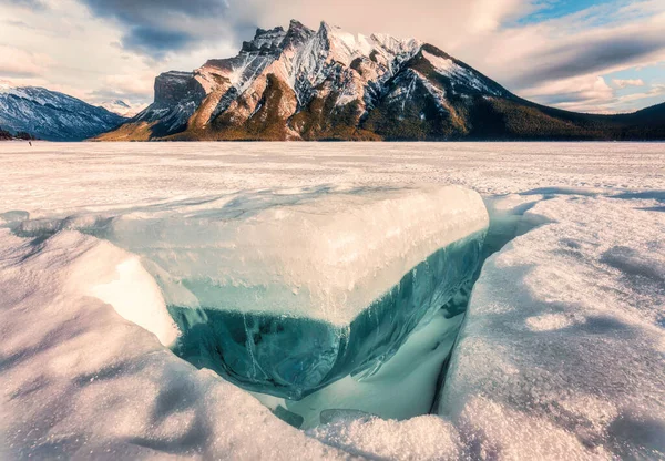 岩だらけの山々と冬のバンフ国立公園 アルバータ州 カナダの冬の湖からの砕けた氷を持つ凍った湖Minnewankaの美しい景色 — ストック写真