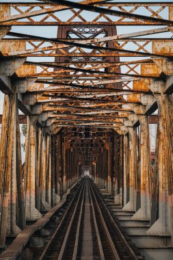 Eski paslı demir tren yolu. Hanoi şehrindeki yol üzerindeki Long Bien köprüsü.