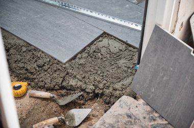 Müteahhit, beton ve banyo yenileme aletleriyle granit döşeme ile çalışıyor.