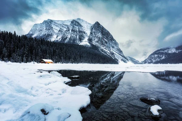 在加拿大艾伯塔省班夫国家公园 路易斯湖美丽的风景 有木制小屋 灯火通明 山体岩石 冬季白雪覆盖 — 图库照片