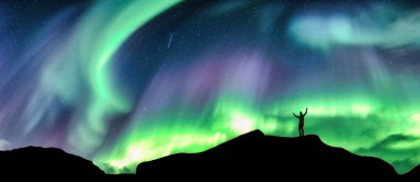 Panorama güzel Aurora borealis, Kuzey ışıkları gölgede parlayan yürüyüşçü gecenin karanlığında gökyüzünde Kuzey Kutup Dairesi 'nde duruyor.