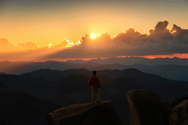 stock image Commitment hiker man standing and looking the view on top of mountain during sunset in tropical rainforest at national park