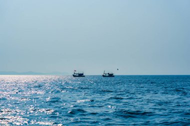 Güneşli bir günde mavi denizde yüzen geleneksel balıkçı teknesi
