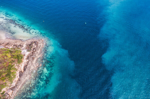 Вид сверху на красивое голубое и бирюзовое море у побережья на острове Фалал летом