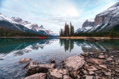 Güzel, dünyaca ünlü ve ikonik Spirit Adası. Erkek turist, Kanada 'nın Alberta kentinde Jasper Ulusal Parkı' ndaki Maligne Gölü 'nde ahşap iskelede yürüyor.