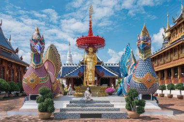Asyalı kadın turist Wat Ban Den ya da Wat Den Salee Sri Muang Gan 'a ibadet etmeye gelir Lanna tarzı tapınak ve renkli heykel Chiang Mai, Tayland' da güneşli bir günde