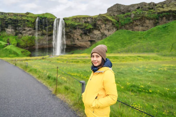 Boldog Fiatal Ázsiai Turista Sárga Dzsekiben Áll Előtt Seljalandsfoss Vízesés — Stock Fotó