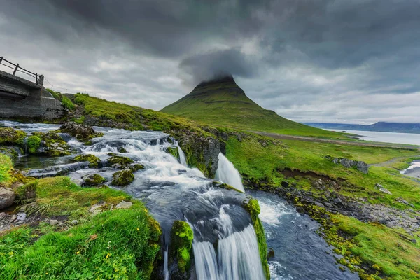 カークフォール山とアイスランドの夏に流れる滝の上に美しい気分の雲 — ストック写真