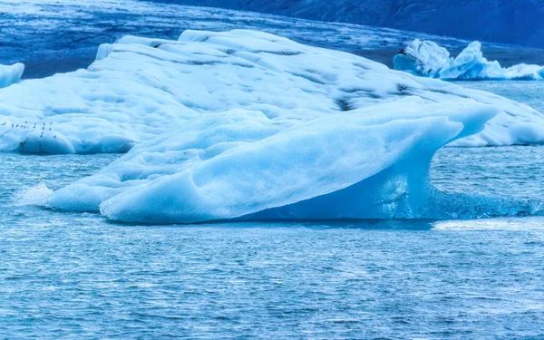 アイスランドの夏にジョクルサロン氷河のラグーンに浮かぶ美しい天然の青い氷山 — ストック写真