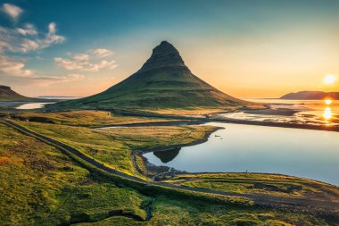 İzlanda 'nın Snaefellsnes yarımadasında güneş doğarken gölün yansımasıyla görkemli simetri volkanı Kirkjufell Dağı manzarası